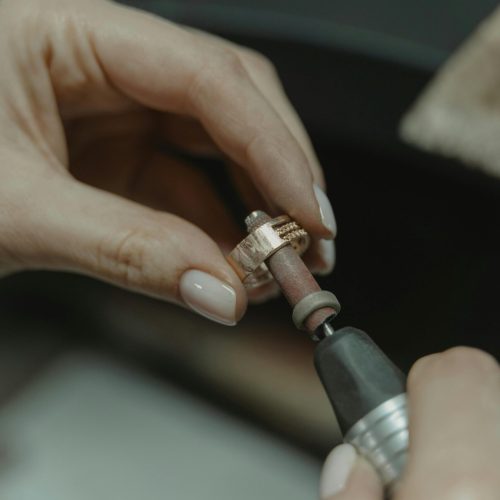 Detailed shot of a skilled jeweler meticulously polishing a ring.