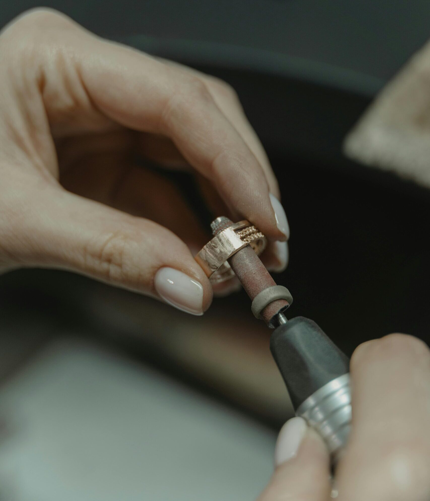 Detailed shot of a skilled jeweler meticulously polishing a ring.